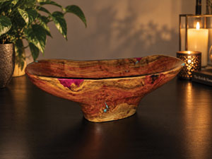 An wooden bowl made by Bob Proctor accented with magenta and turquoise inlay