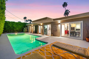 photo of back of house with pool and lounge chairs